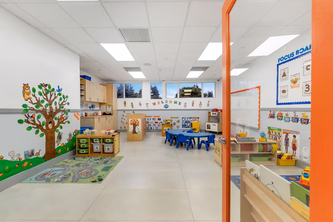a watch me grow classroom with a tree mural on the wall.