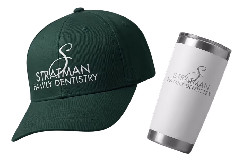 Black fitness tracker, green folded jacket with white earphones, and black massage gun labeled Theragun Prime.
