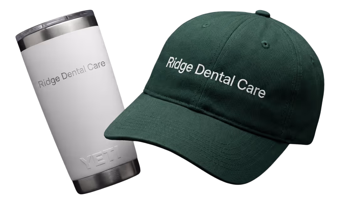Black fitness tracker, green folded jacket with white earphones, and black massage gun labeled Theragun Prime.