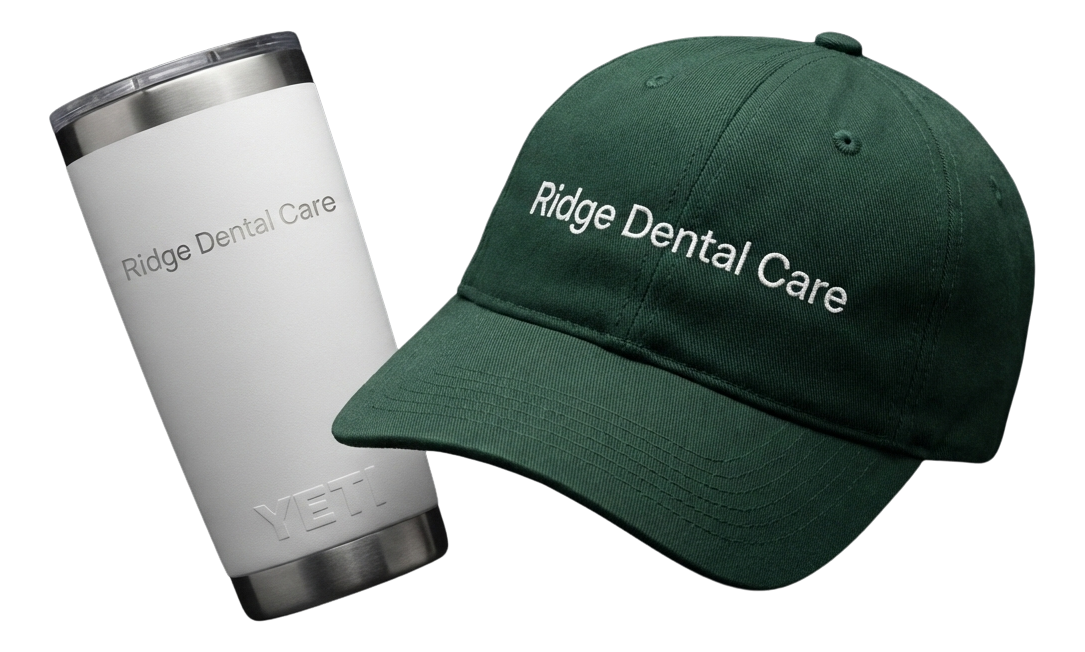 Black fitness tracker, green folded jacket with white earphones, and black massage gun labeled Theragun Prime.