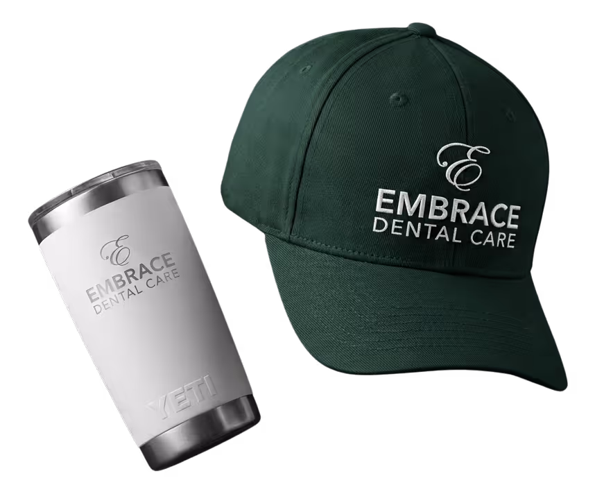 Black fitness tracker, green folded jacket with white earphones, and black massage gun labeled Theragun Prime.