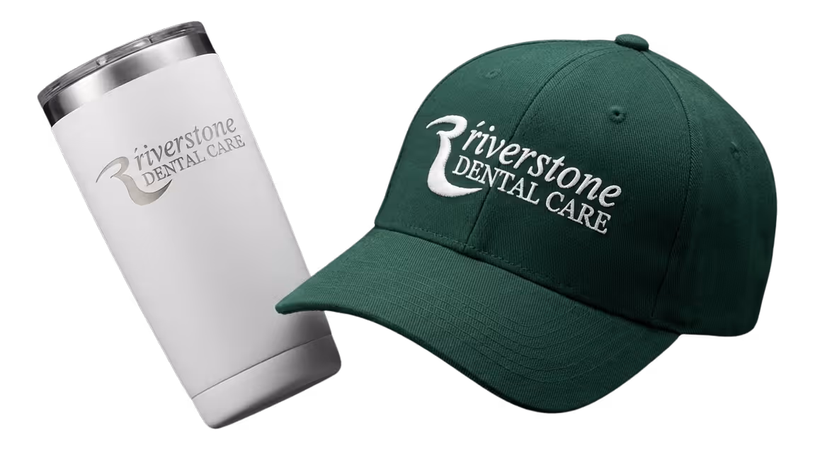Black fitness tracker, green folded jacket with white earphones, and black massage gun labeled Theragun Prime.