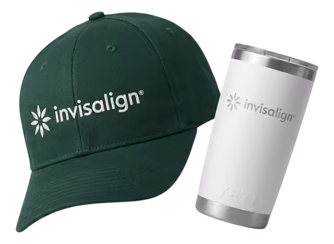Black fitness tracker, green folded jacket with white earphones, and black massage gun labeled Theragun Prime.