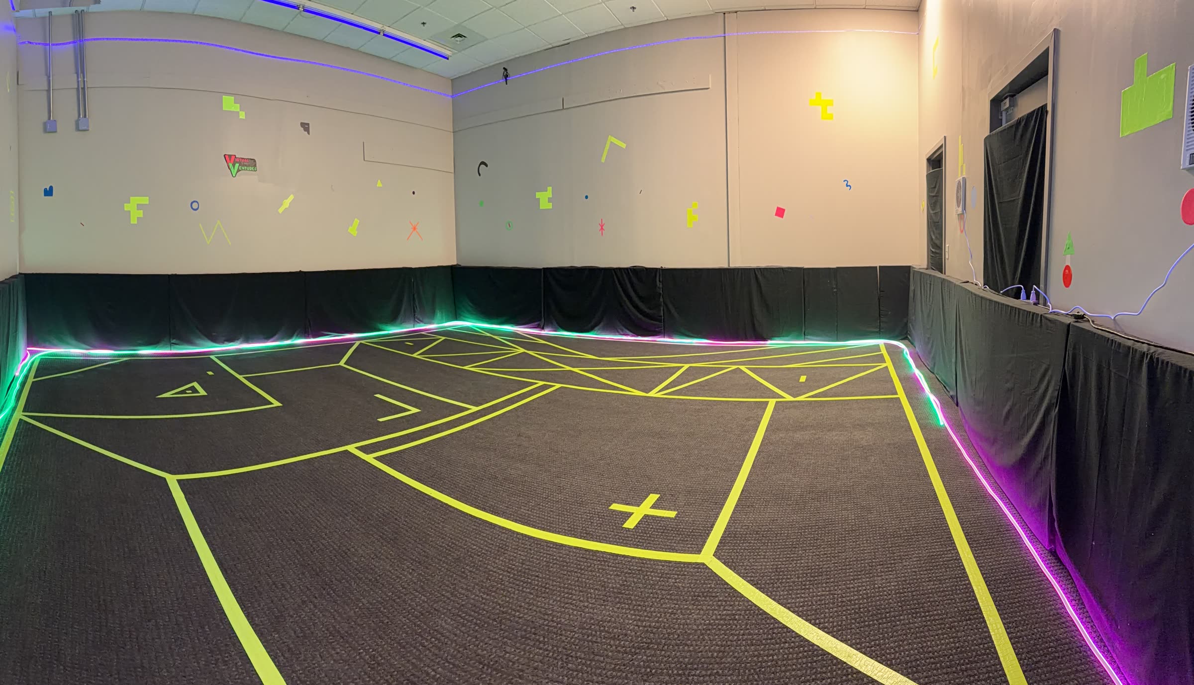 The free-roam VR arena at Virtual Ventures in Davenport, lit with neon edge lighting