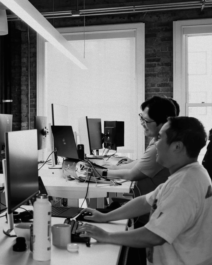A man is sitting at a desk with a laptop and a mouse.