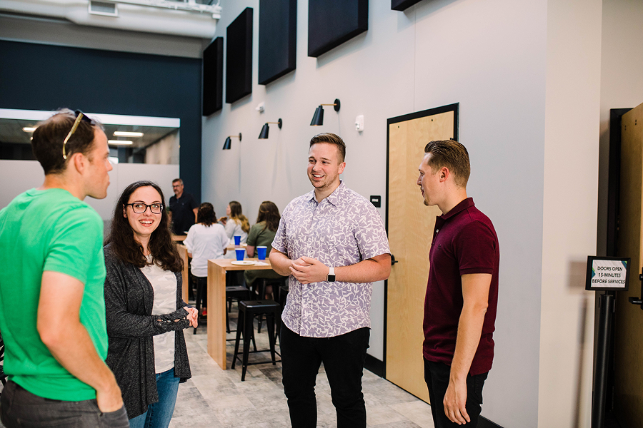 A few young men and a woman standing and chatting