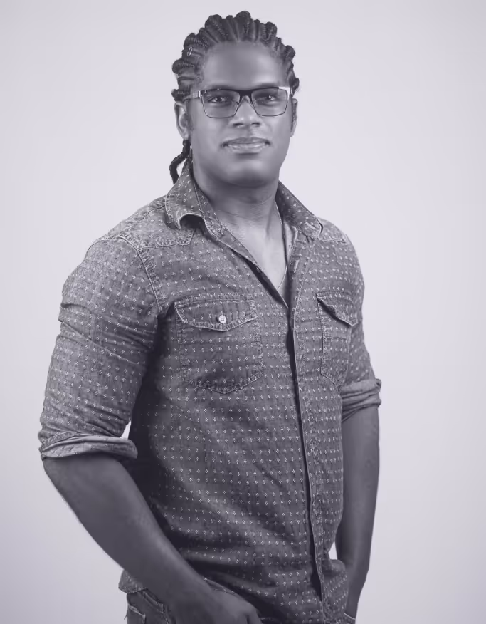 a man with braided hair wearing glasses