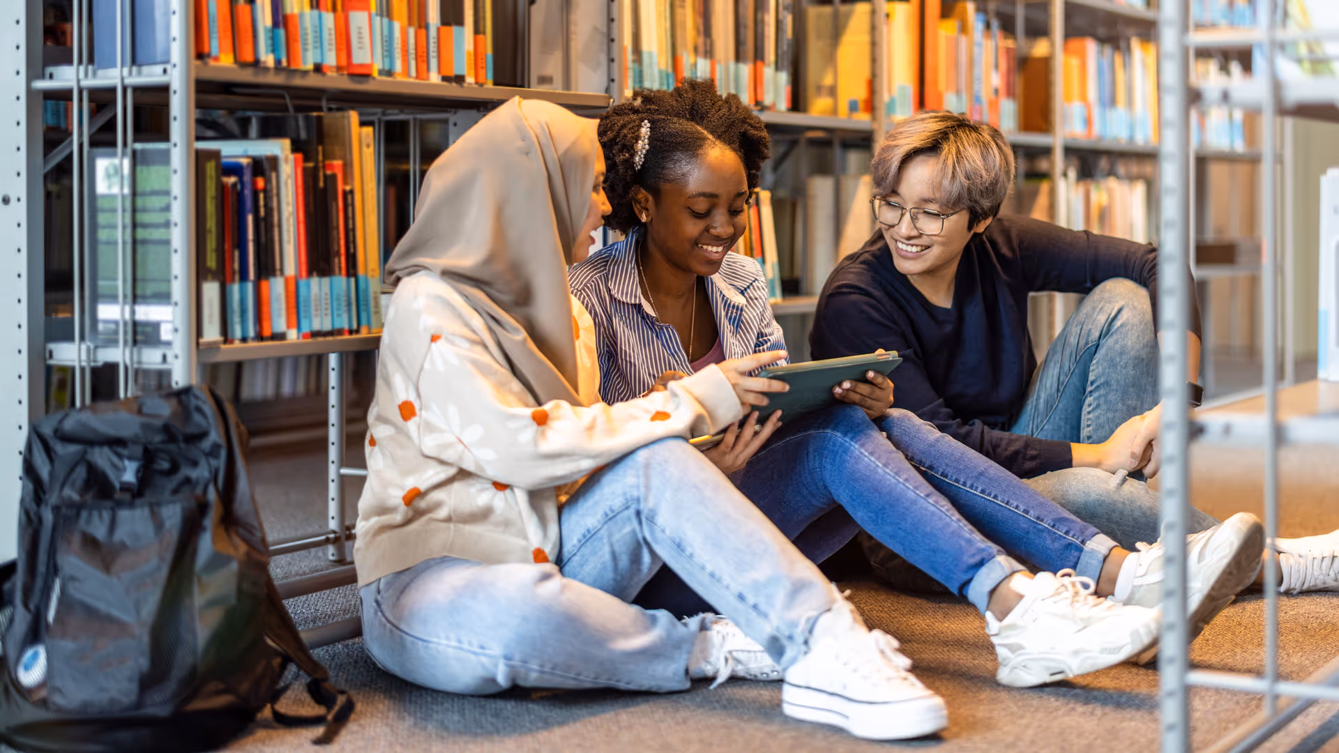 Multiethnic group of students sitting in a library and studying together
