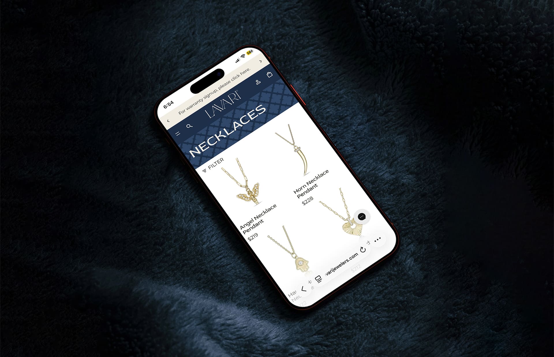 Smartphone displaying Lavari website with gold necklaces on a dark blue textured fabric background.