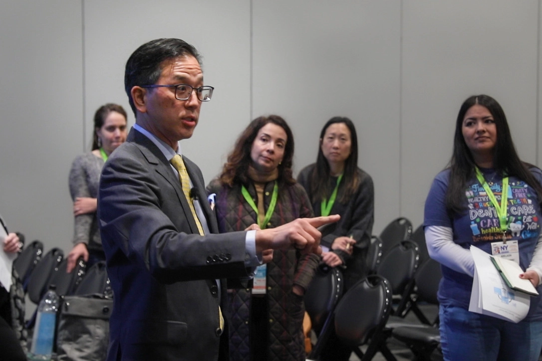 Dr. Marn addresses a small audience during a professional conference, engaging participants in discussion.