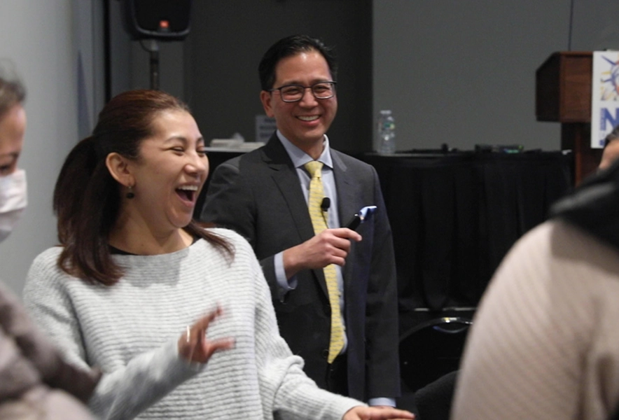 Dr. Marn smiling as conference attendees laugh and engage in an interactive session.