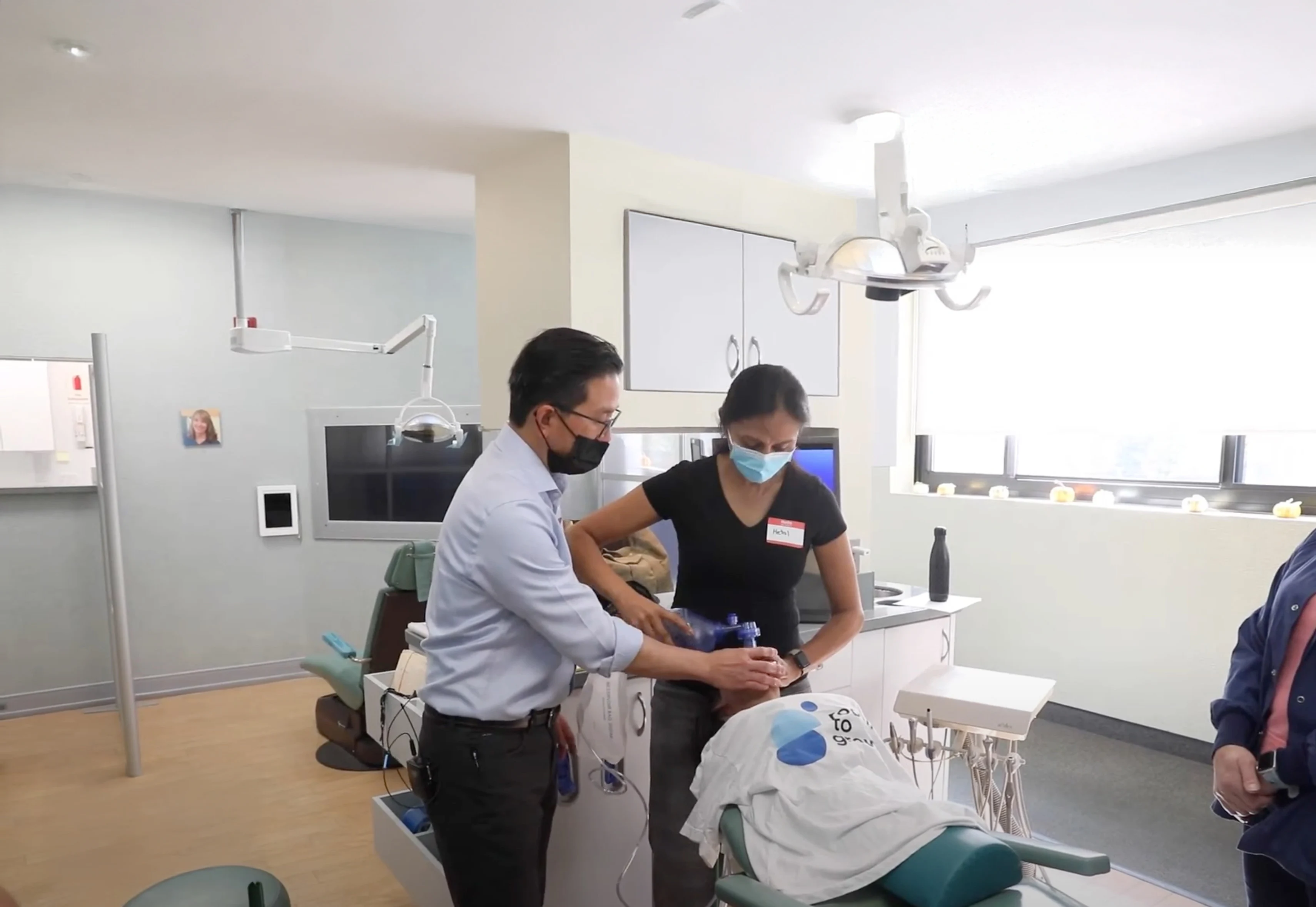 Dr. Marn training a staff member in clinical techniques inside a modern dental office.