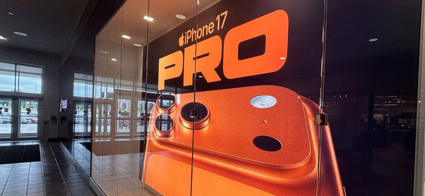 Resource Integrated team installing iPhone 17 window graphics at TELUS retail location