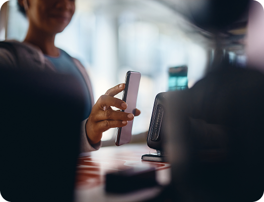 Gym goer paying or checking in with mobile phone