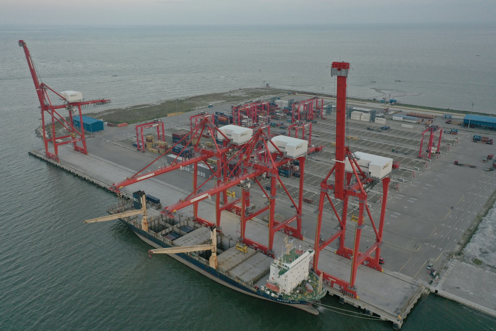 Cargo ship docked at a port with large cranes