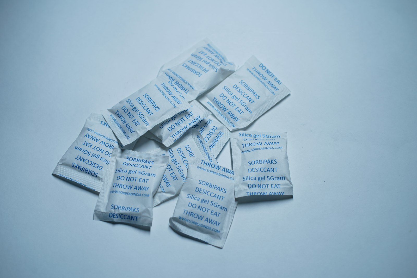 Small desiccant packets on a light background