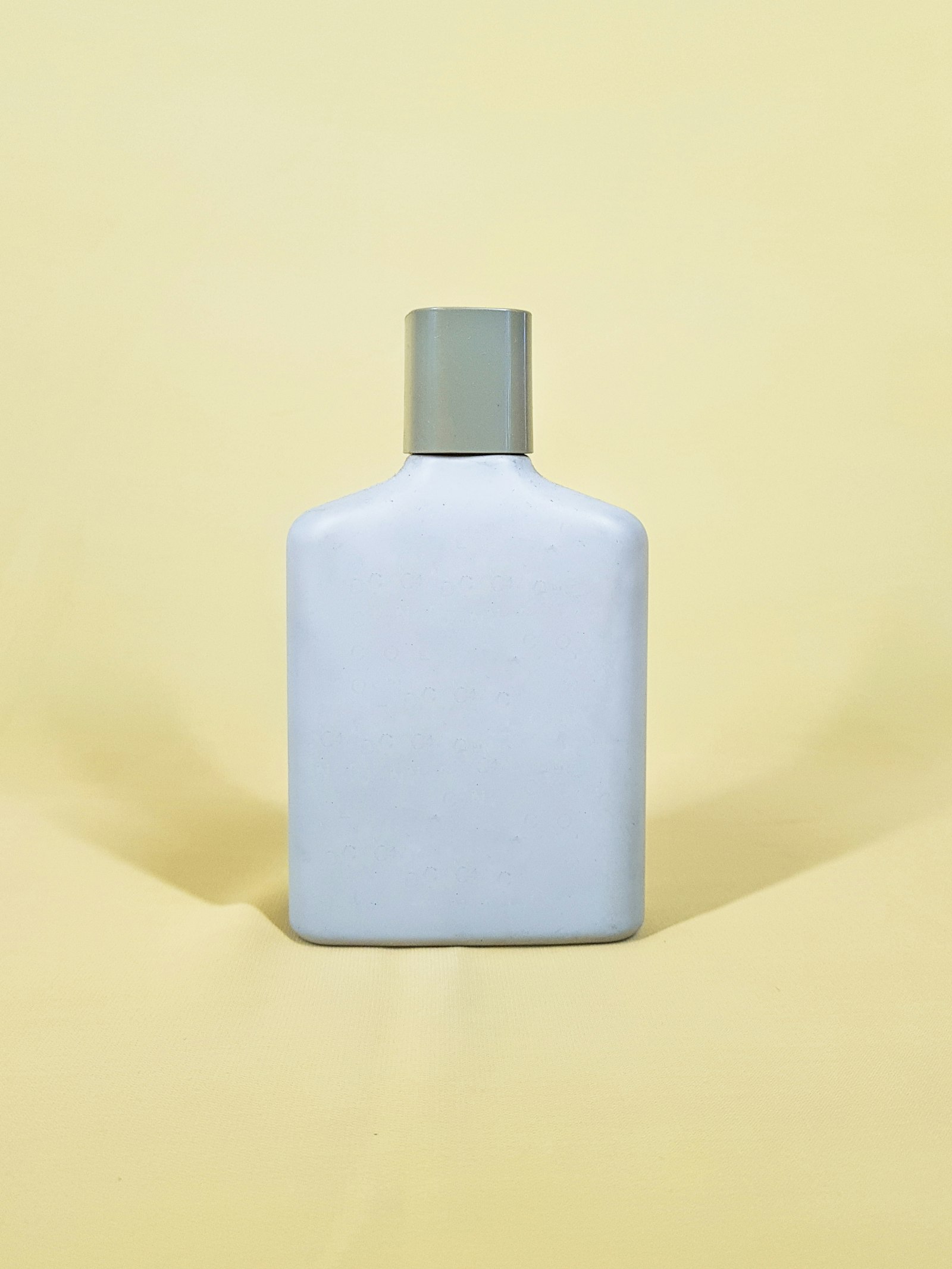 White and black bottle on yellow table