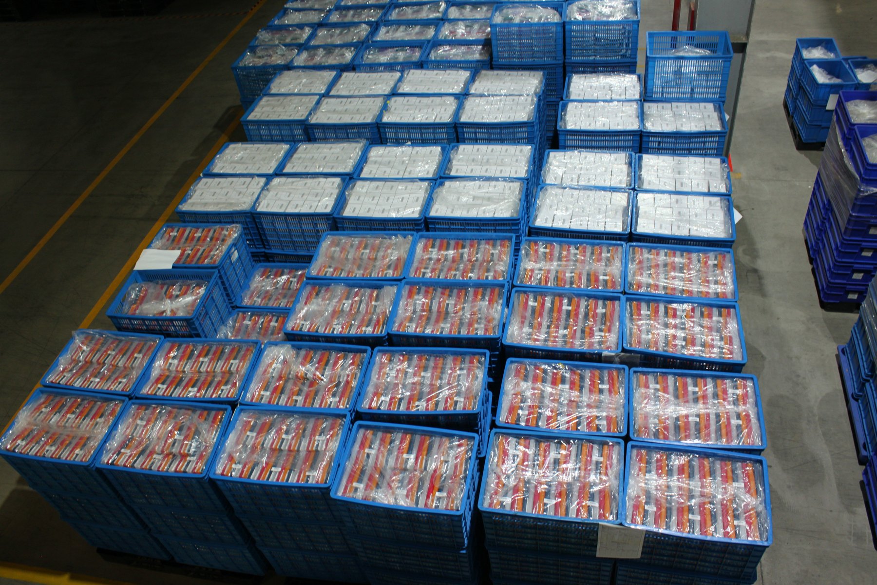 Finished molded parts case-packed in crates and staged on the warehouse floor for outbound shipment