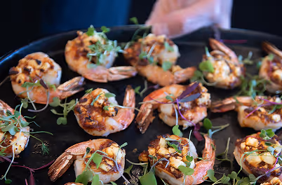A pan filled with cooked shrimp and vegetables.