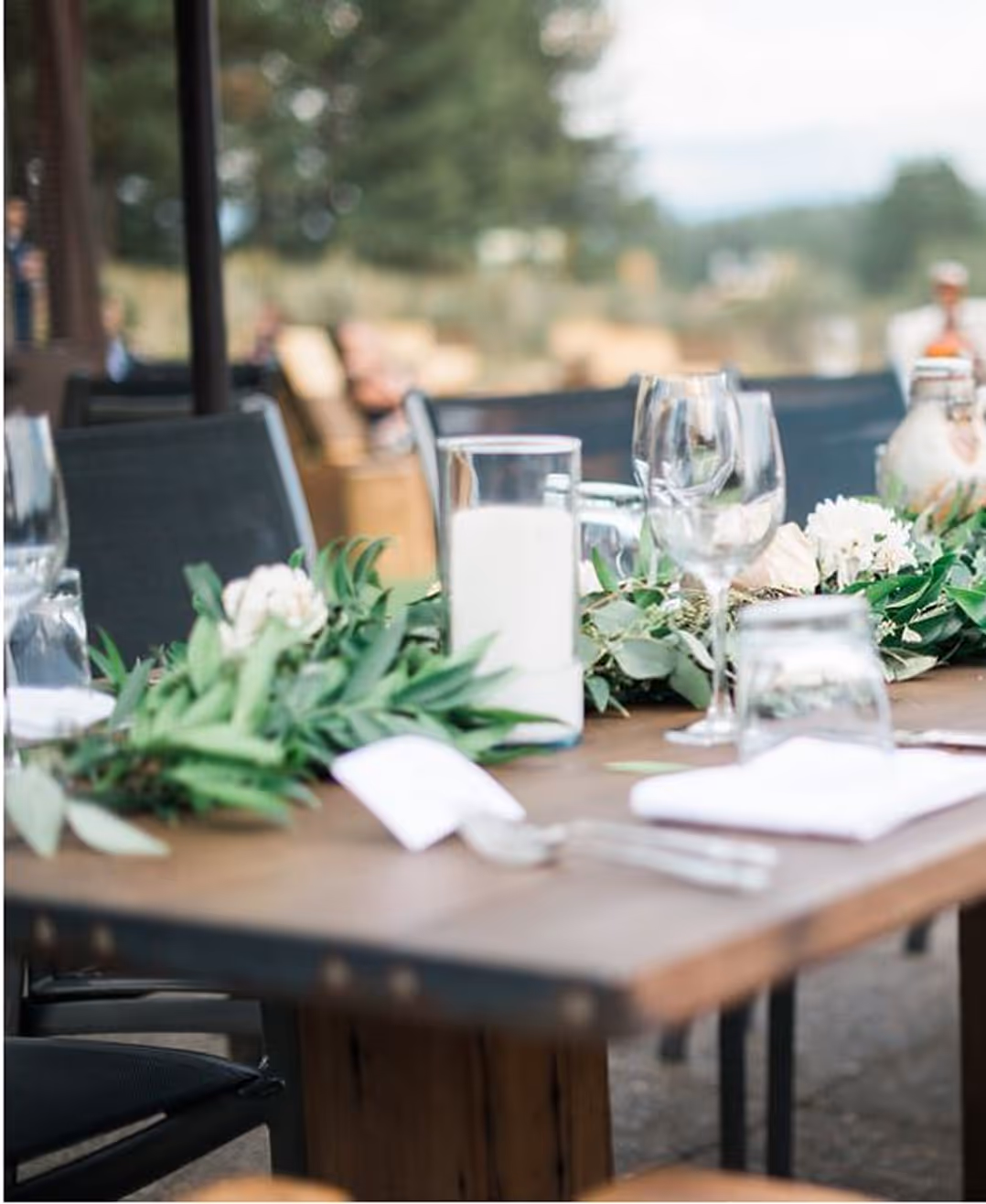 A wooden table topped with lots of white flowers.