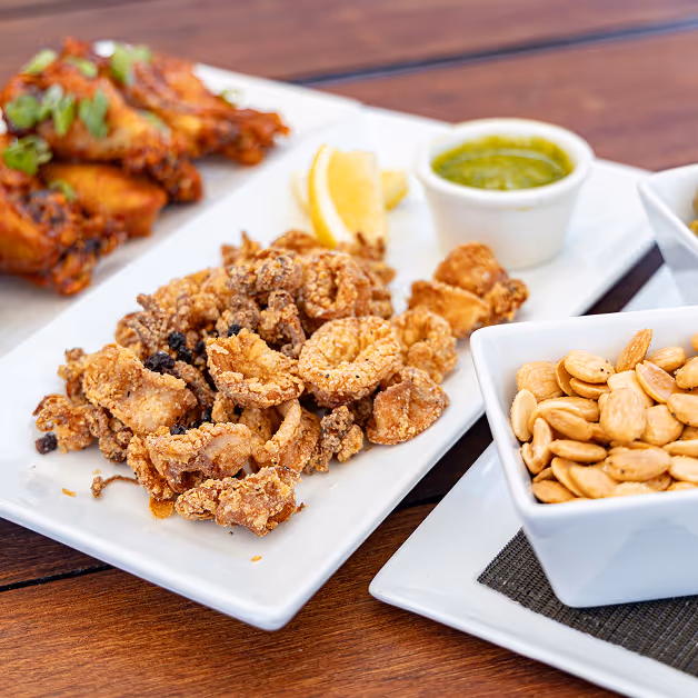 A wooden table topped with plates of food.