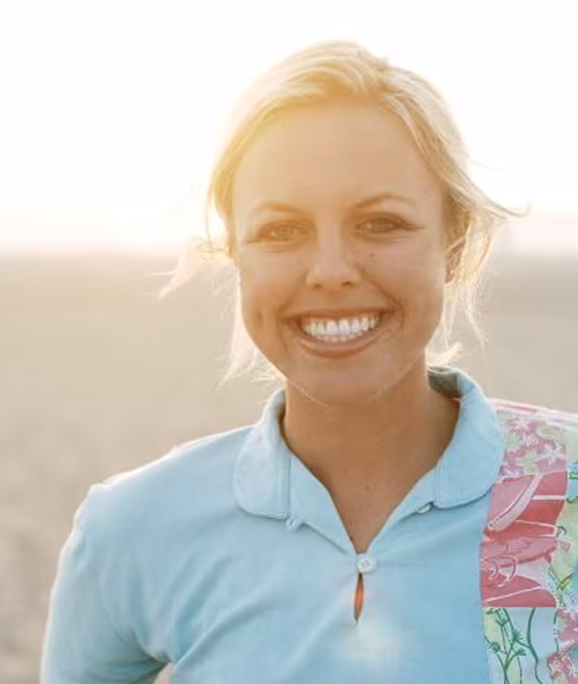 A woman with a blue shirt is smiling.