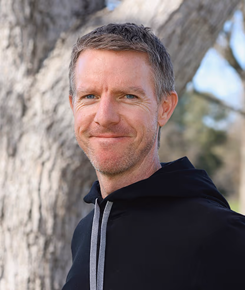 A man standing in front of a tree.