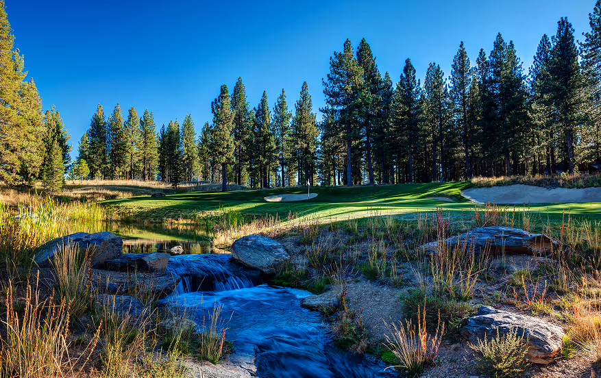 A golf course with a stream running through it.