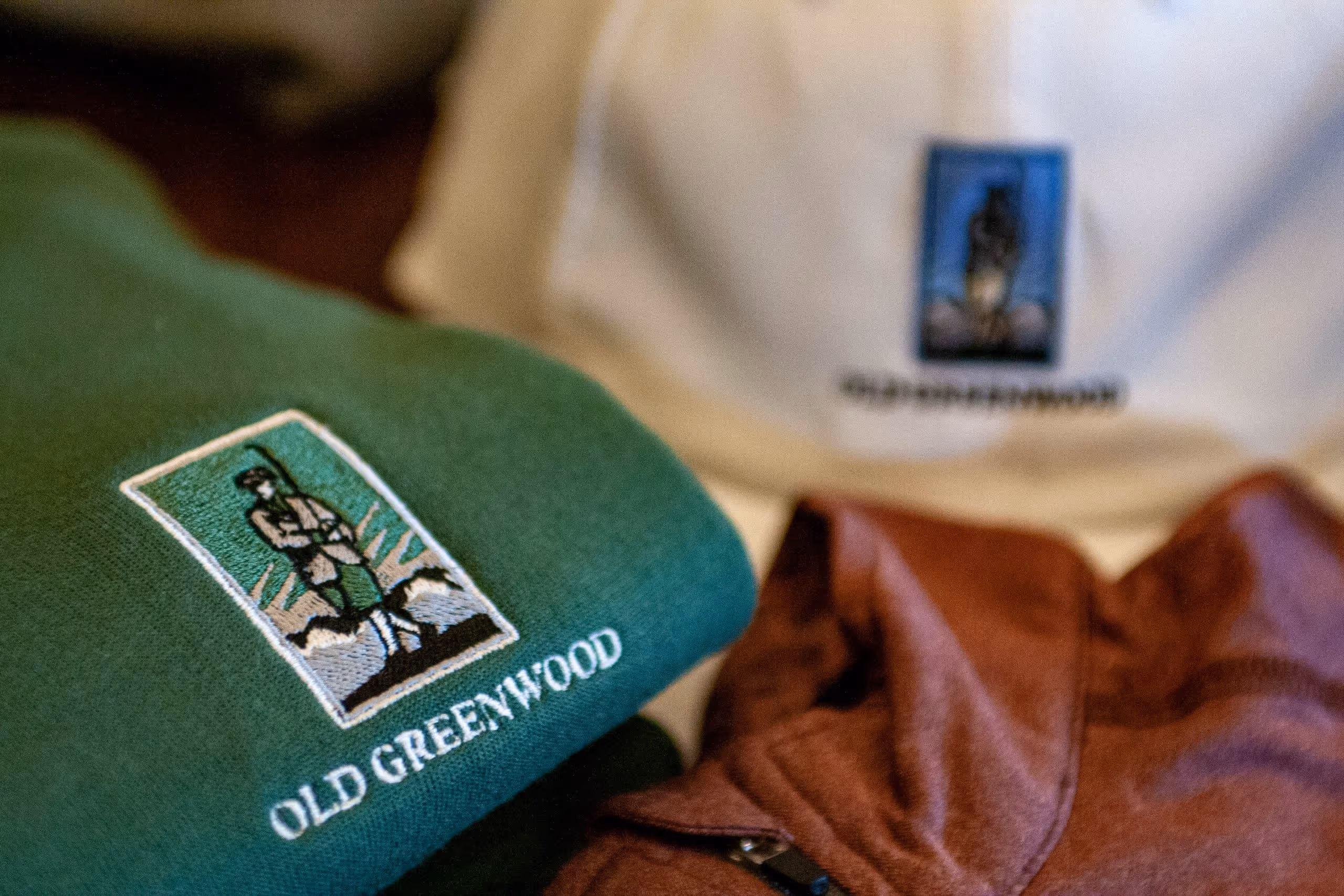 Clothing with embroidered Old Greenwood logo showing a standing frontiersman with a rifle.
