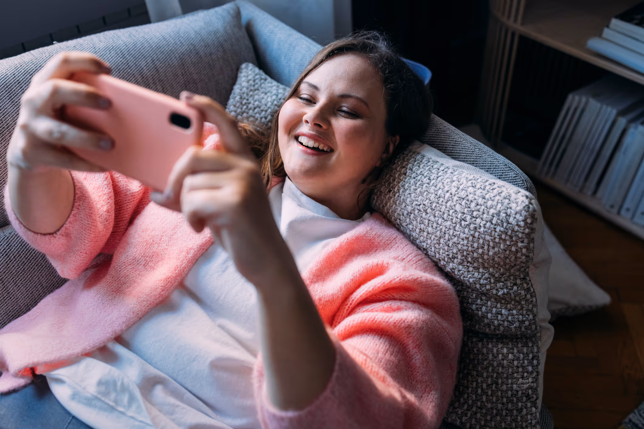 Patiënt gebruikt smartphone voor digitaal consult vanuit bed thuis