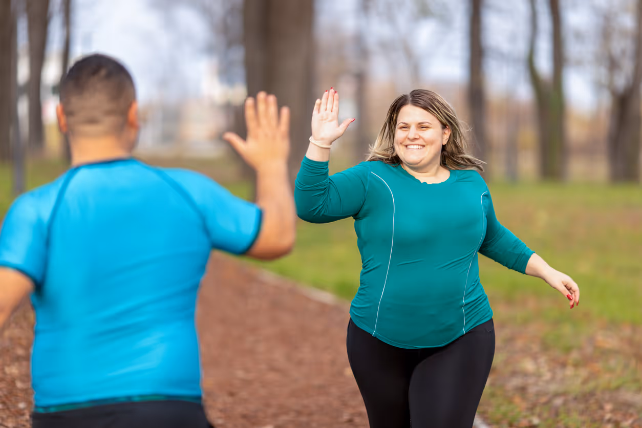 2 mensen lopen hard llangs elkaasr en geven elkaar een high five
