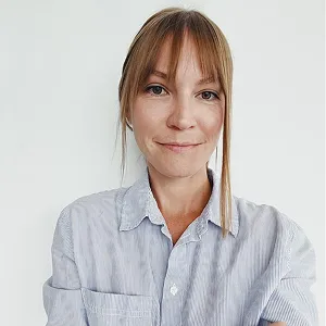 Portrait of woman in blue shirt, looking at camera (neutral expression)

