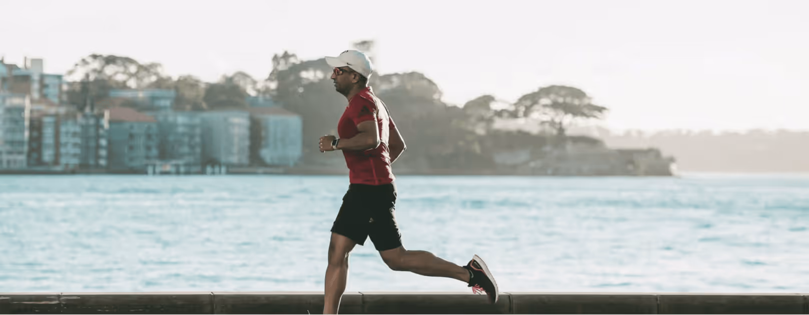 Man jogging outdoors in a red shirt, representing the energy, stamina, and overall vitality benefits of optimized testosterone health through Gameday Men’s Health.