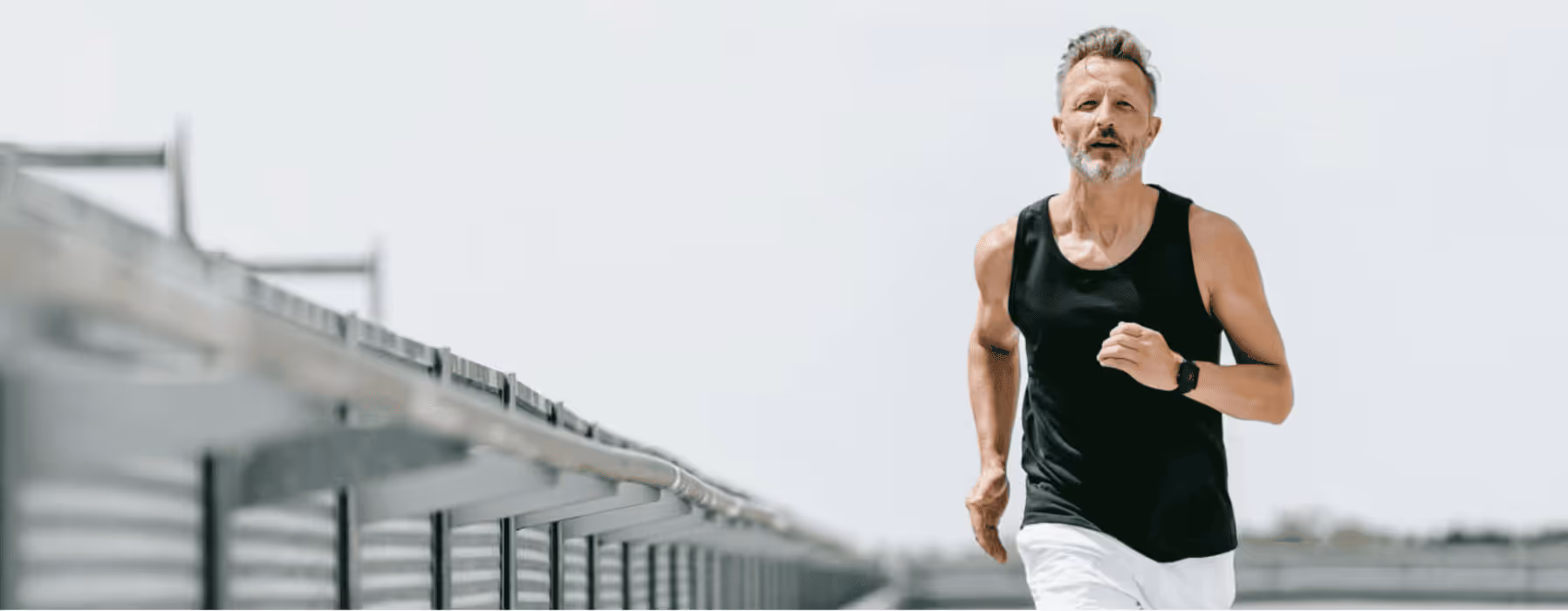 Fit middle-aged man jogging in athletic wear, representing the energy and confidence benefits associated with Gameday Men’s Health medical weight loss solutions.