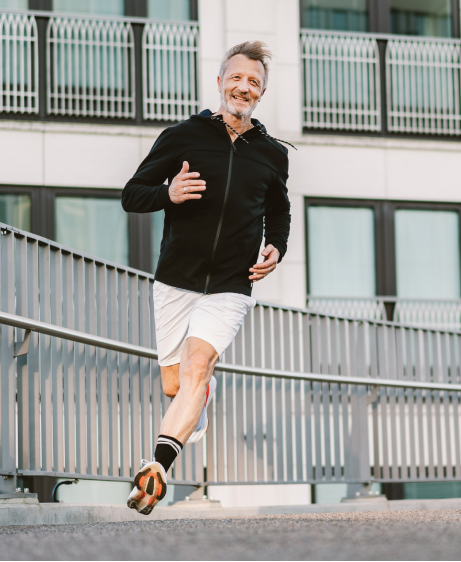 Older man running in the city after musculoskeletal shockwave therapy recovery
