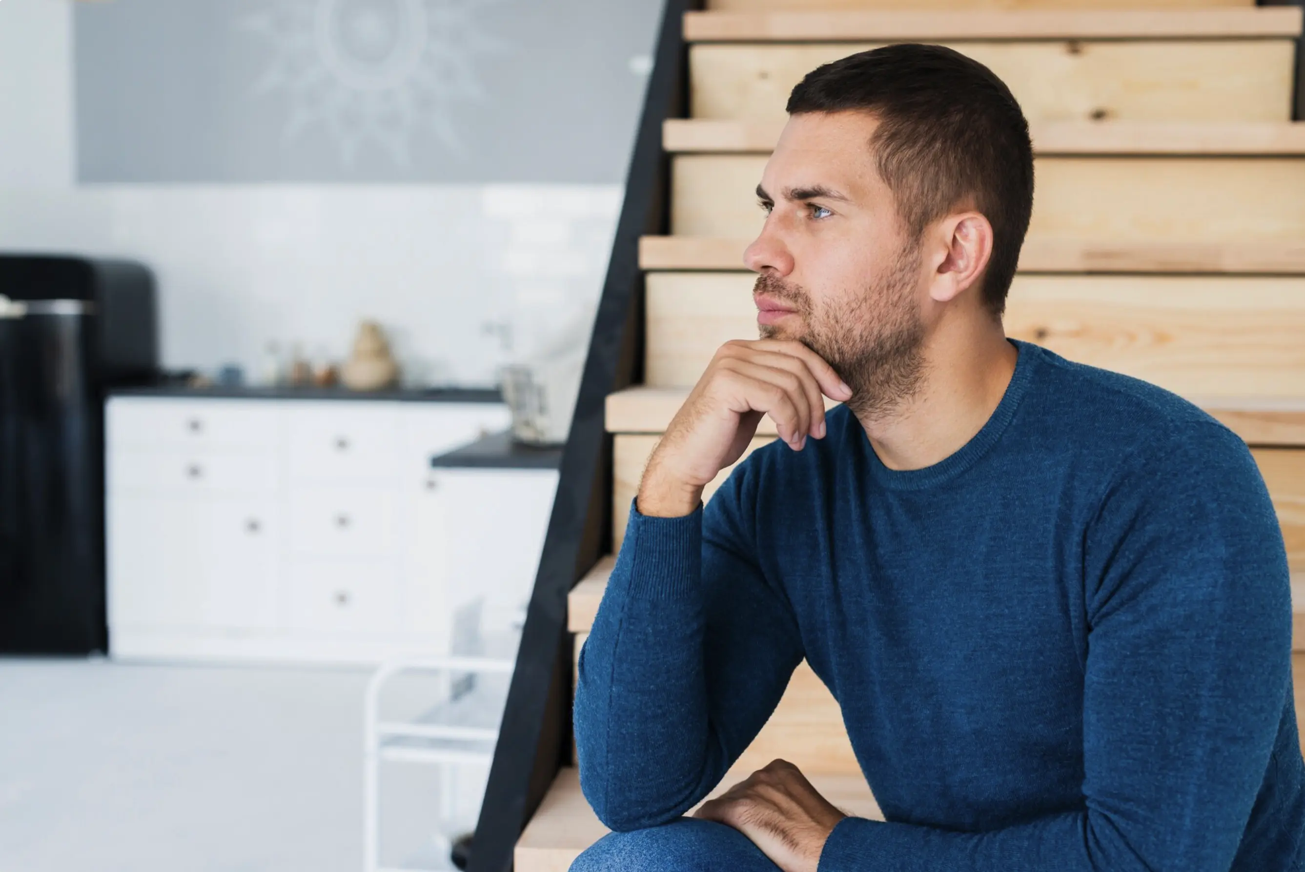 Thoughtful man sitting at home, considering the differences between peptides and steroids