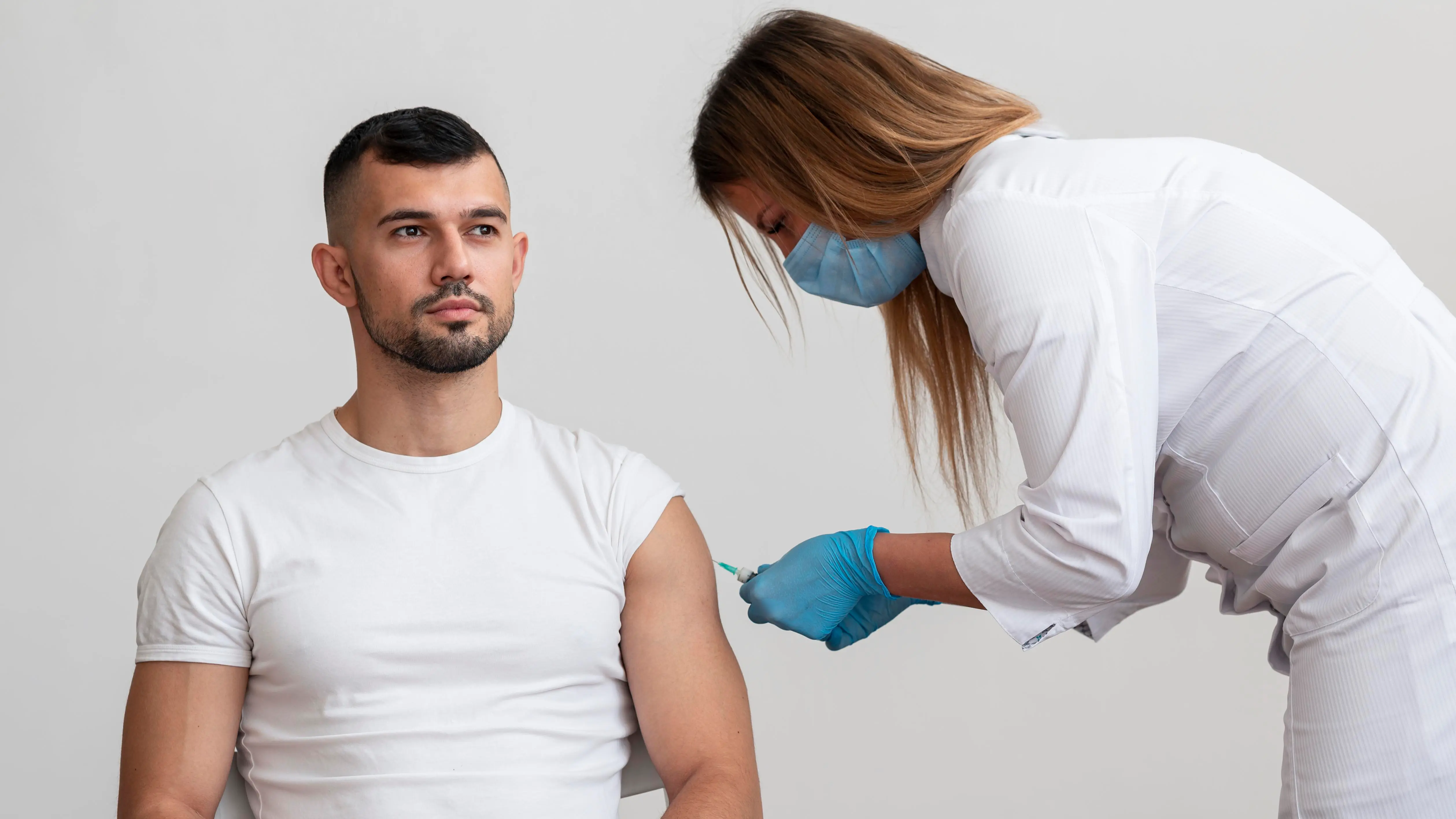 A healthcare provider administering a testosterone injection to a man during a medically supervised TRT appointment, representing safe and legal testosterone replacement therapy.