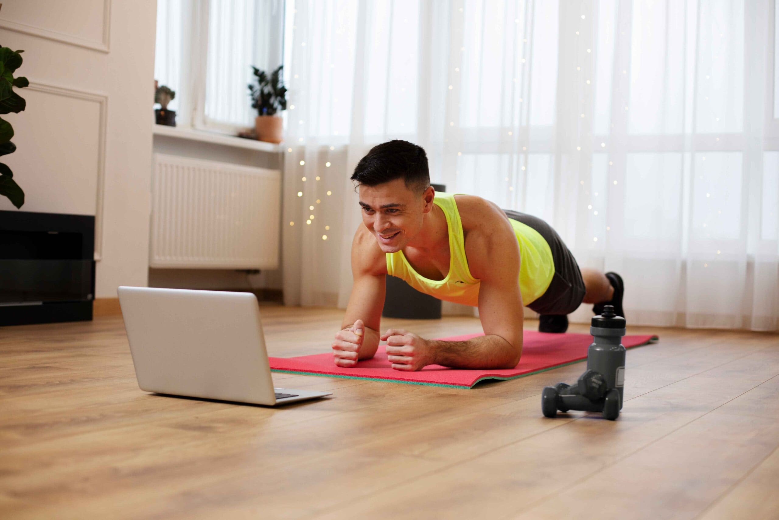 Man holding a plank position while following a virtual workout at home, symbolizing the role of fitness, motivation, and hormone optimization in tailoring the right TRT dosage.
