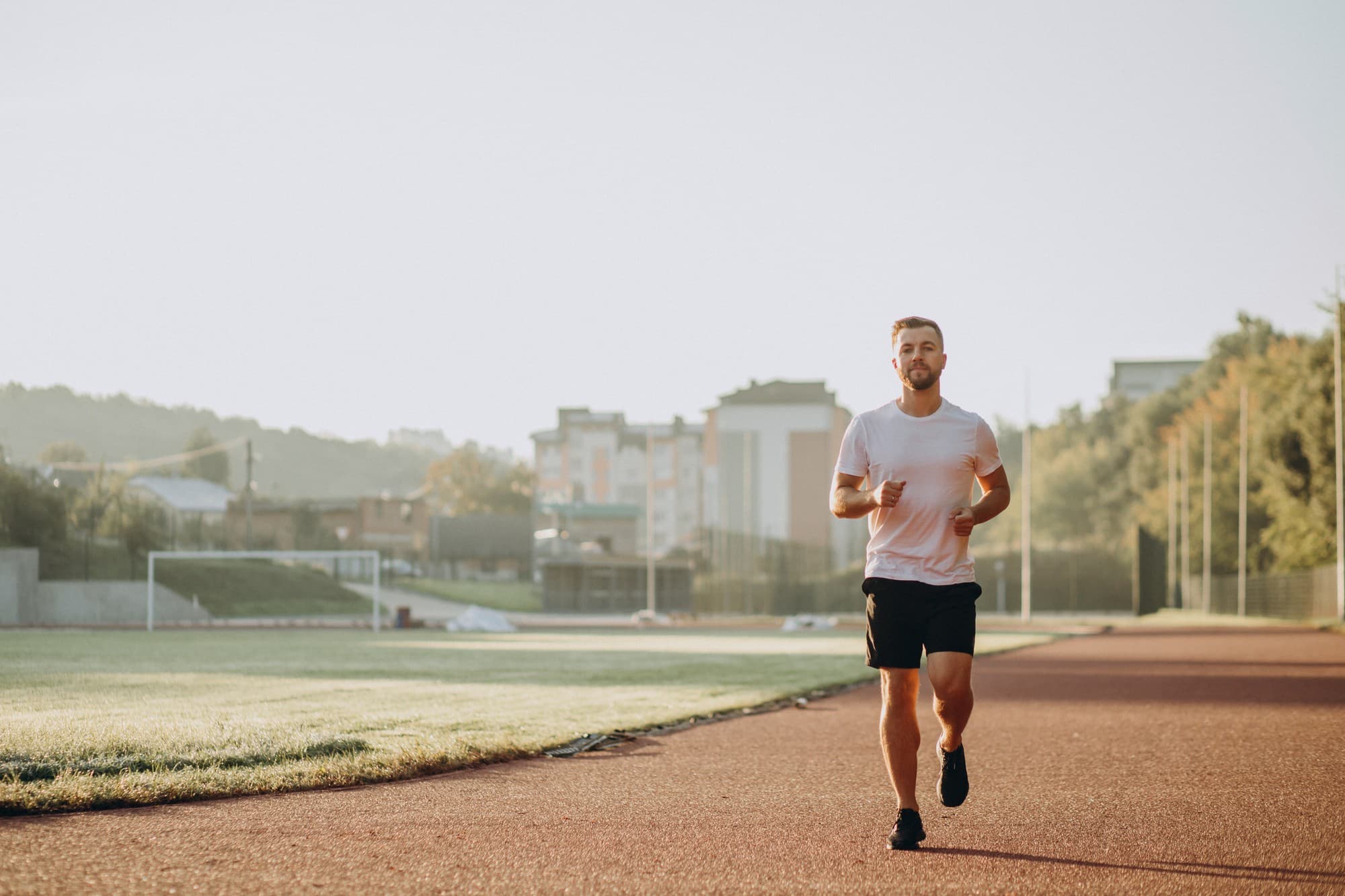 A focused man jogging outside, representing the physical performance and overall wellness benefits often associated with testosterone treatment.