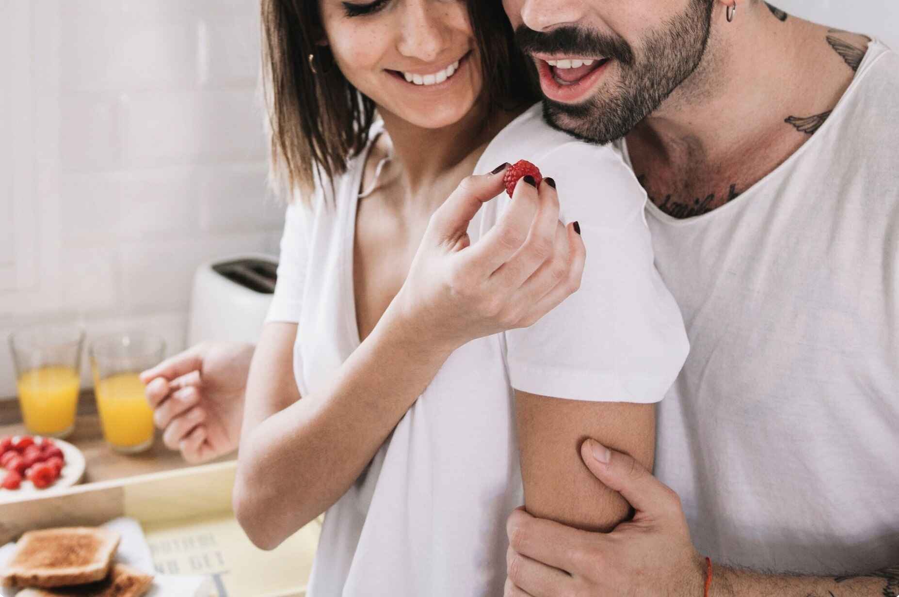 Couple enjoying time together in the kitchen, reflecting confidence, intimacy, and sexual health balance.