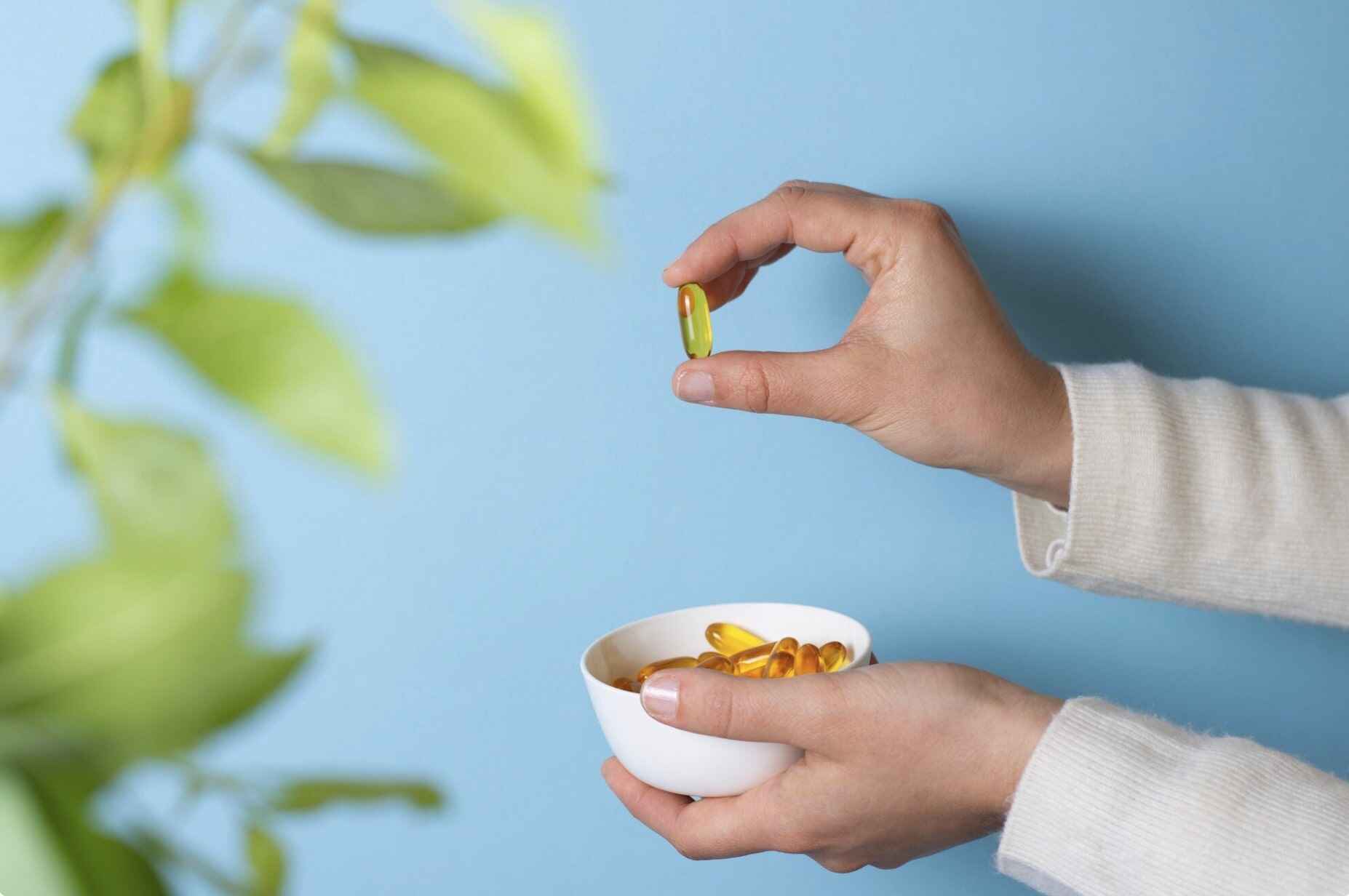 Man’s hand holding a vitamin supplement designed to support libido and sexual health.