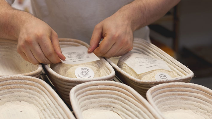 A loaf of sourdough with a wafer oaoer poem baked into the bread crust.