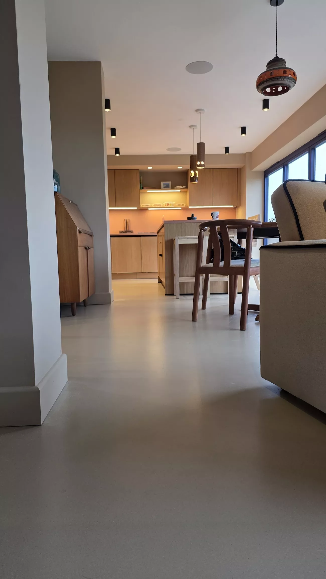 Concrete overlay flooring flowing through dining and kitchen space with polished concrete overlay finish