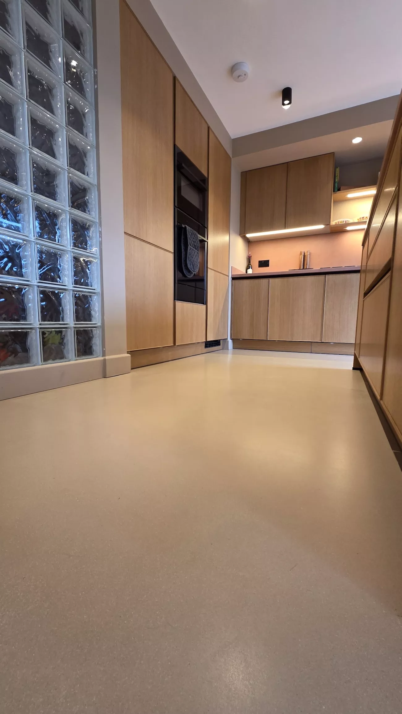 Polished concrete overlay kitchen with island unit and seamless concrete overlay flooring in light ash brown finish