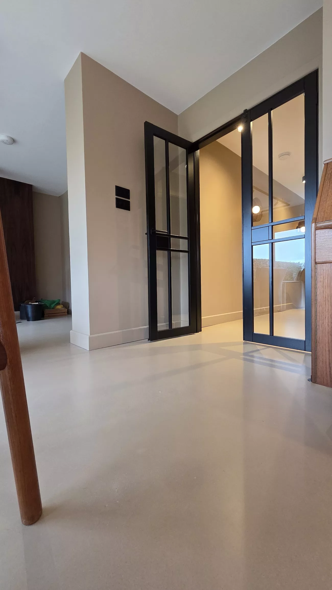 Polished concrete overlay kitchen floor with warm wood cabinets and seamless concrete overlay finish