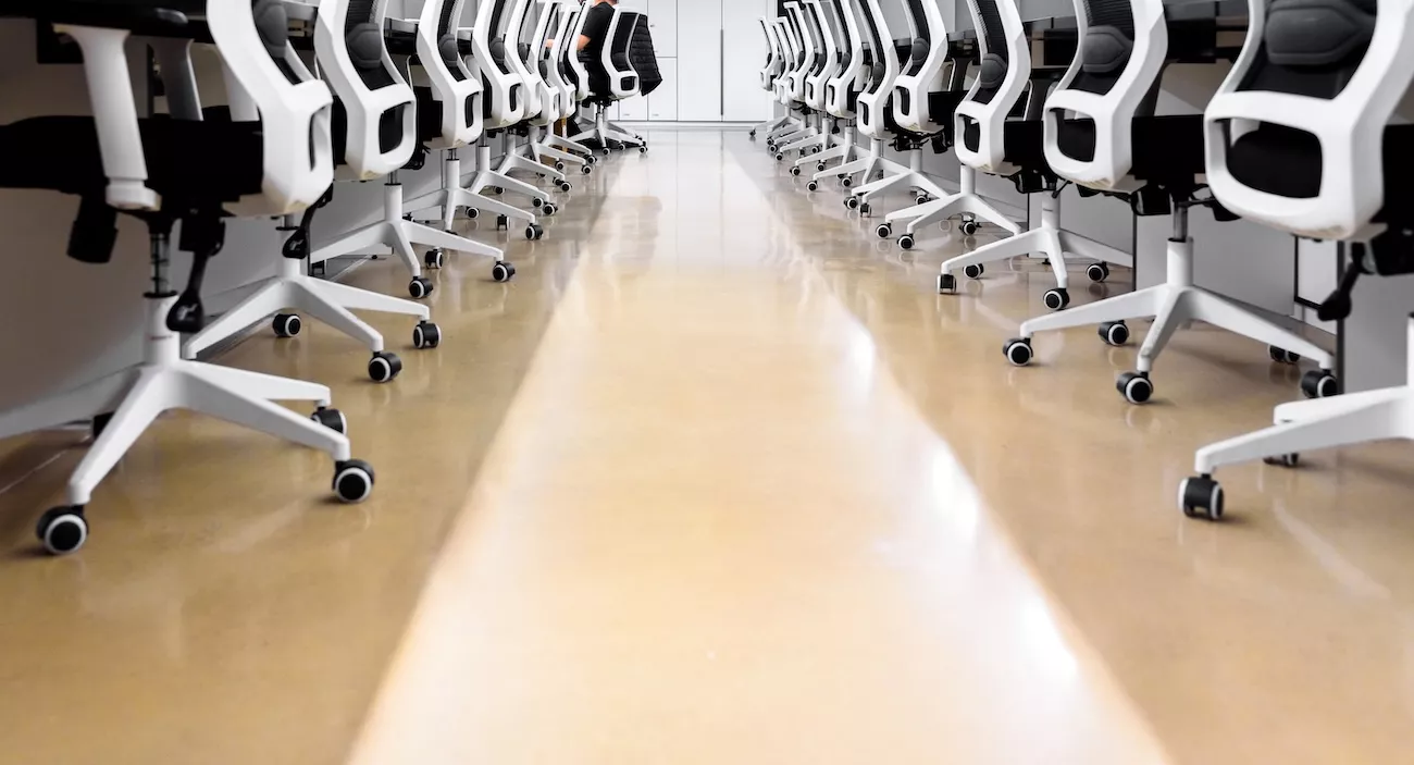 Glossy polished concrete floor running between rows of ergonomic office chairs in a UK office