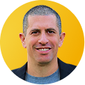 Ofer Hermoni Ph.D., Portrait of a smiling man with short hair wearing a gray shirt and brown jacket.