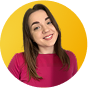 Smiling woman with long wavy hair wearing a dark sweater against a yellow circle background.