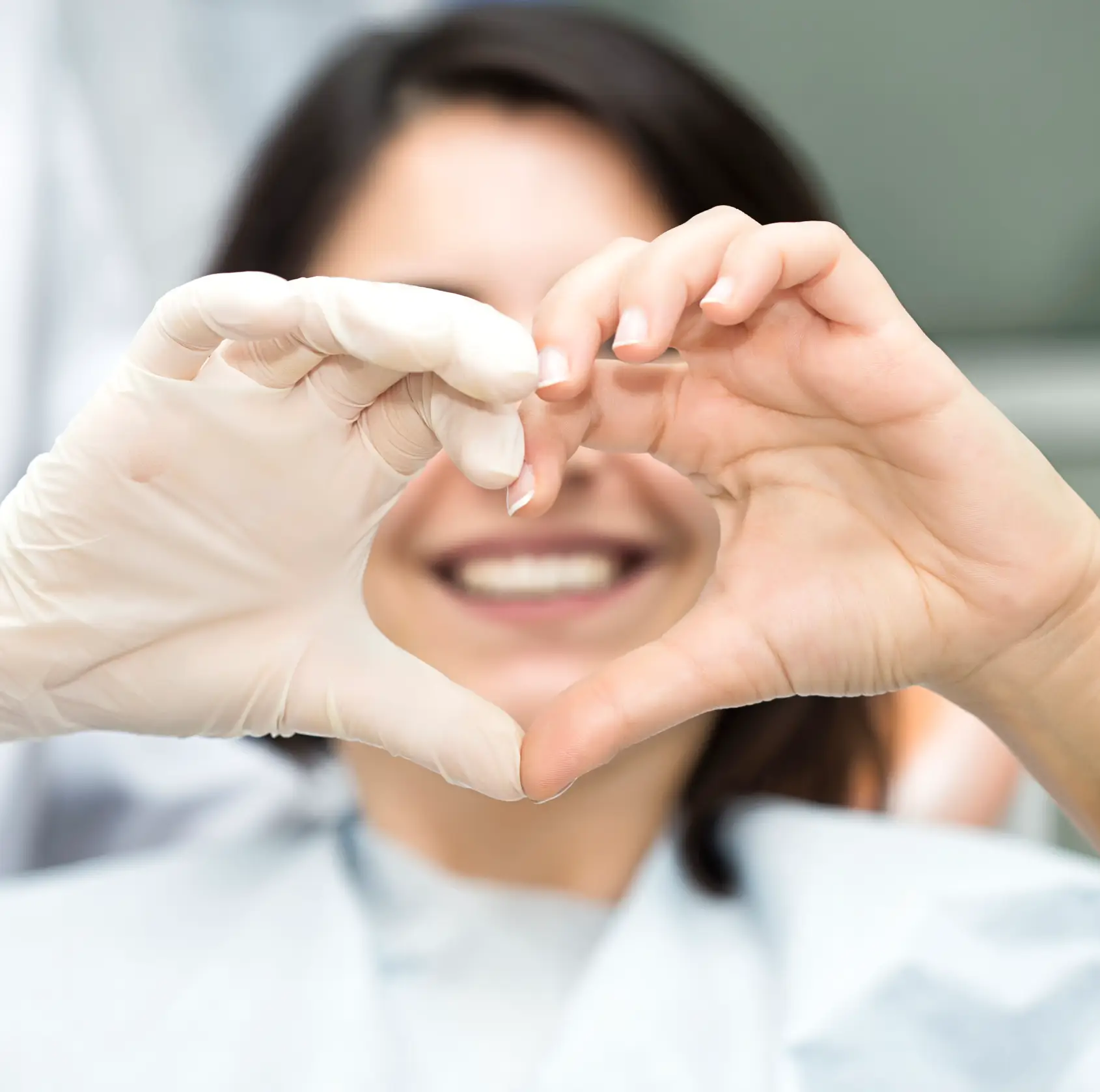 Patient making a hearth with her hand and dentist's hand