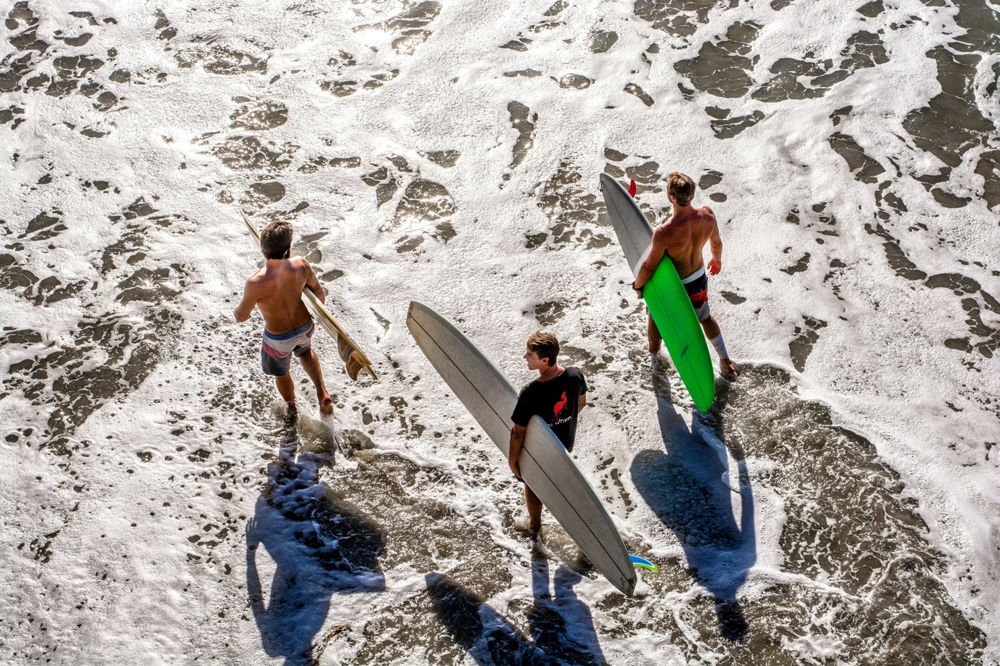 A group of surfers are going to the ocean